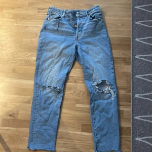 Blå jeans  - Säljer ett par jeans i storlek 40 men dom är små i storleken och passar mig som vanligtvis har jeans i storlek 36-38. Jeansen är lite ljusare i verkligheten än på första bilden och har slitna hål på knäna. 