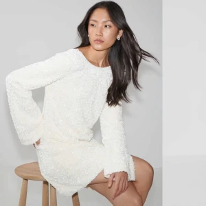 Vit paljettklänning från Gina Tricot - Helt oanvänd med prislappen kvar! Jättefin vit klänning med paljetter från GinaTricot i storlek XS.