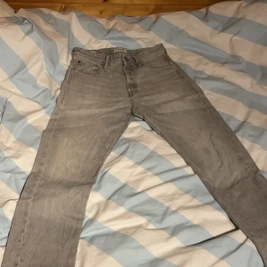 Grå jeans från Jack & Jones - Snygga grå jeans från Jack & Jones med klassisk design. De har en rak passform och är tillverkade i slitstarkt denim. Perfekta för en avslappnad stil. 