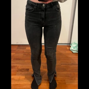 Svarta jeans med slits - Snygga svarta jeans med hög midja och klassisk femficksdesign. Perfekta för en stilren look och passar till det mesta i garderoben.