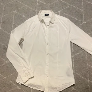 Armani skjorta - Snygg vit skjorta från Armani med broderad logga på bröstet. Strlk: S skick 9/10. Undrar ni något så är det bara att höra av sig 🙌