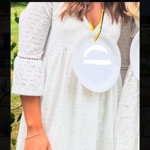 Vit klänning från Vero Moda - Säljer min fina studentklänning. En vit kortklänning från Vero Moda med v-ringning och trekvartsärmar. Otroligt skön klänning som inte skaver och är perfekt att bära under en hel dag. Klänningen har ett fint broderat mönster och volangdetaljer vid ärmsluten. Perfekt som studentklänning! Jag köpte klänningen  för 600kr från Vero Moda och den är endast använd en gång och är i väldigt bra skick!