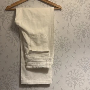Vita jeansbyxor - Snygga vita jeansbyxor med klassisk design. Perfekta för en stilren look. De har en rak passform och är tillverkade i ett slitstarkt material.