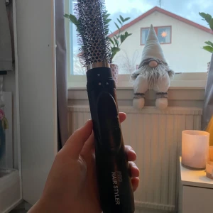 Hårstyler - Säljer en värmeborste. Perfekt för att skapa volym och lockar. Den har en svart design med silverdetaljer och flera värmeinställningar. Lätt att använda och smidig att ta med på resor. Använd en gång 