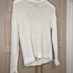 Vit stickad tröja från Gina Tricot - Mysig vit stickad tröja från Gina Tricot. Perfekt för kyliga dagar med sin bekväma passform och långa ärmar. Enkel och stilren design som passar till det mesta.