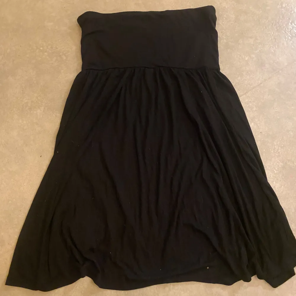 Snygg svart axelbandslös klänning från Esmara. Perfekt för en stilren look med sin enkla design. Klänningen har en bekväm passform och är lätt att matcha med olika accessoarer.. Mekot.
