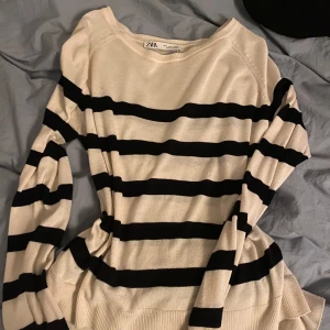 Randig tröja från Zara - Säljer en snygg randig tröja från Zara i beige och svart. Tröjan har långa ärmar och en bekväm passform. Perfekt för en stilren look.