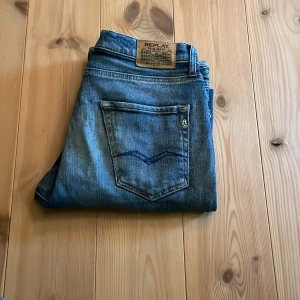 Replay jeans Thad - Säljer ett par blå jeans från Replay. De har en normal passform. Perfekta för en avslappnad stil. Jeansen är i modellen Thad. Storleken är 166cm. Dem passar bra om man är från 165cm-175cm lång. Det är en defekt på byxorna och det är att dem är ganska slitna som har gjort så att det är ett litet hål vid högra benet.