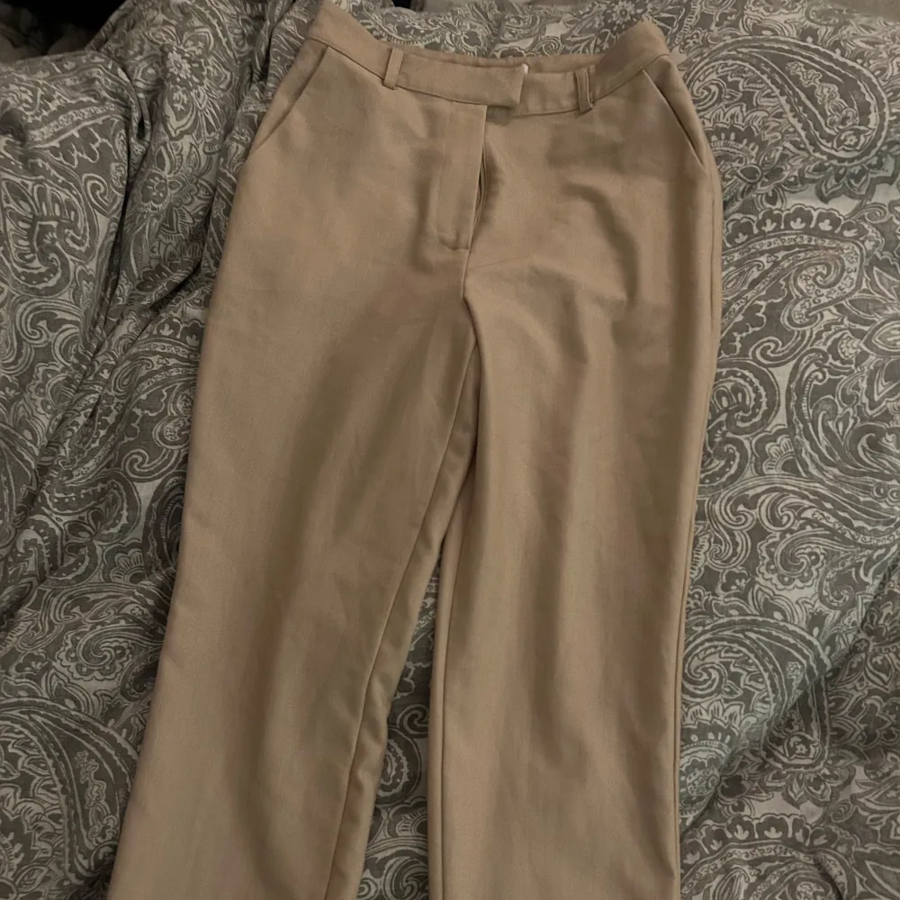 Snygga beige kostymbyxor från NA-KD med slits nere på byxorna. Knappt använda och inga defekter. . Farkut & Housut.