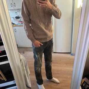Merinoull hoodie - Säljer en supermysig beige merinoull hoodie som är perfekt för kyliga dagar. Som aldrig har varit buren, tröjan är helt ny och är i sprillans nytt skick! Den har en klassisk design med dragsko i huvan och ribbade muddar vid ärmslut och nederkant. Passar både till vardags och för en avslappnad stil. Perfekt för höst och vinter! Skriv gärna vid funderingar, tröjan passar 160-170cm.