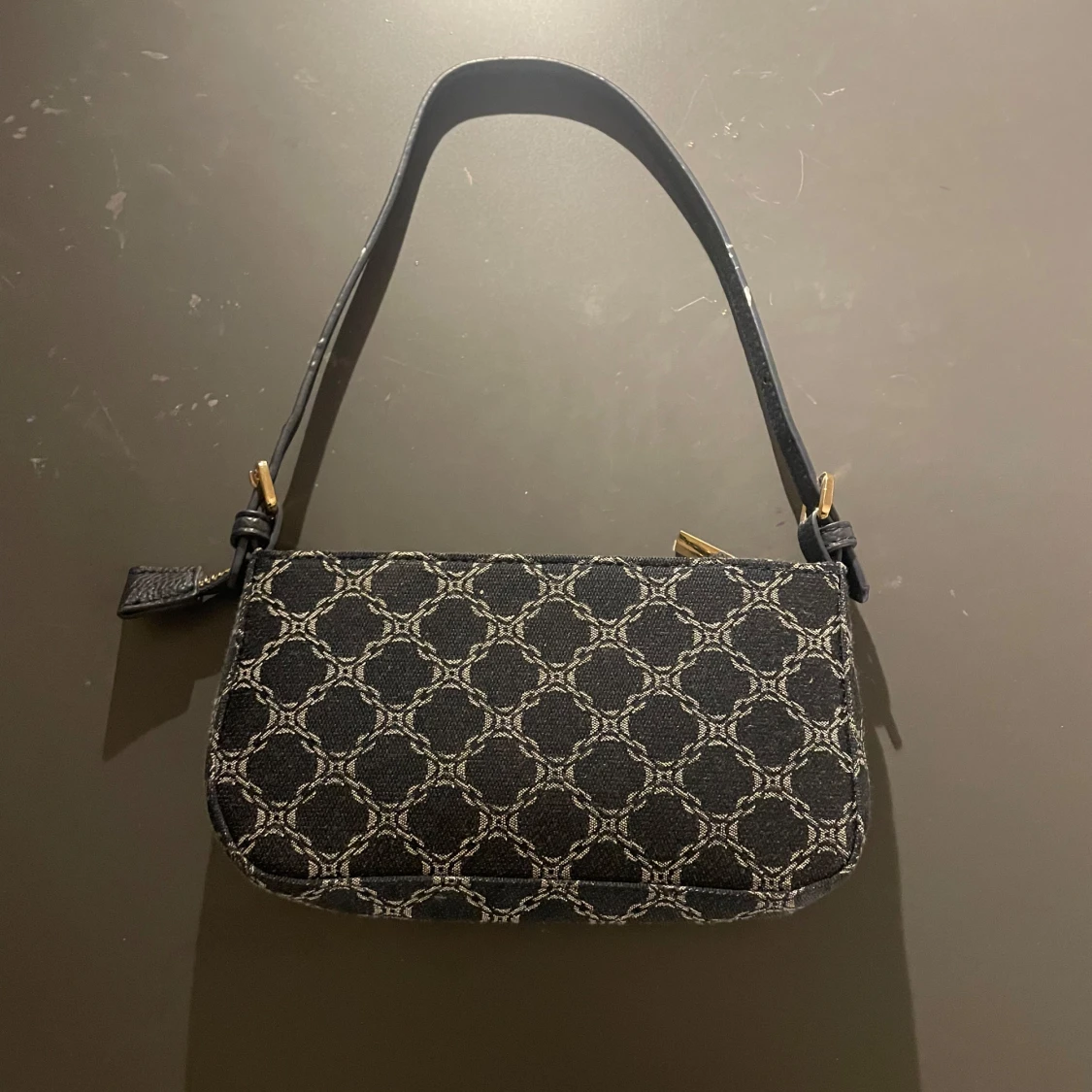 Svart axelväska med mönster