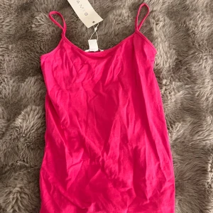 Rosa linne med tunna axelband - Snygg rosa topp från Amisu med tunna axelband. Klänningen är i en härlig rosa färg och har en enkel design.