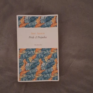 Pride & Prejudice - En vacker utgåva av Jane Austens klassiker 'Pride & Prejudice' från förlaget Modernista. Boken har ett färgglatt omslag med mönster i blått och orange. En tidlös berättelse om kärlek och sociala normer i den engelska adeln.