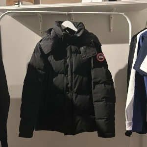 Svart canada goose jacka - Säljer denna riktigt snygga jacka från ”canada goose”. Den är väldigt varm. Storlek large men passar mig som bär medium. Skulle säga att skicket är 7/10. Då den har lite defekter som att den är lite sölblekt och lite små slitage. Armarna är slitna men det går att fixa. Jackan ligger på runt 14.000 ny men med tanke på att den är i detta skick så säljer jag den betydligt billigare. Hör av dig!