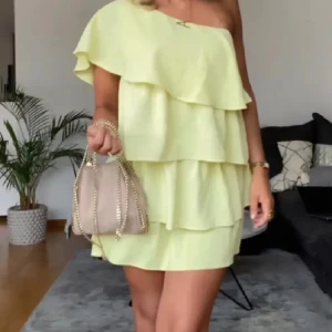 Gul oneshoulder klänning med volanger - Trendig gul oneshoulder klänning med flera lager av volanger. Storlek M men passar S också. Nyskick!