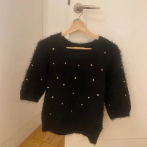 Svart tröja med pärlor från Darling - Säljer en svart tröja från Darling med trekvartsärmar och små pärlor som dekoration. Tröjan är i storlek s men är lite oversize