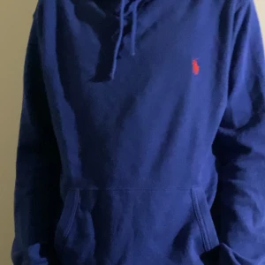 Blå hoodie från Ralph Lauren - Snygg blå hoodie från Ralph Lauren, den har ett skönt stickat material.                                                       Modellen är 174 men den är lite för stor så för den som är längre passar den perfekt. Väldigt bra skick.