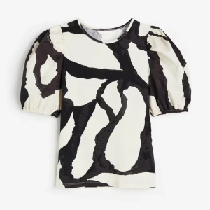 Svartvit mönstrad blus - Snygg blus med svartvitt abstrakt mönster och puffiga kortärmar. Perfekt för en stilren look. Säljer pga att jag inte använder den, jätte fin!💓 Köpte från H&M för två år sedan så den säljs inte längre.