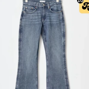 Blå bootcut jeans - Snygga blå bootcut jeans med klassisk femficksdesign och knappgylf. Perfekta för en avslappnad stil med en touch av retro. Passar bra till både sneakers och klackar. Lite slitning nere vid jeansen
