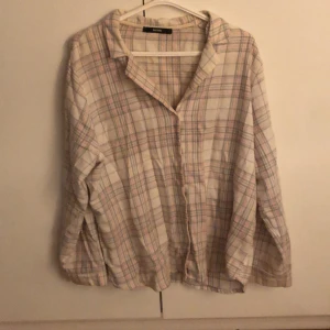 Rutig skjorta från BikBok - Säljer en stilren rutig skjorta från BikBok i ljusa färger. Skjortan har långa ärmar och en klassisk krage. Perfekt för en avslappnad look. Skjortan passar perfekt till vardags men också som en pyjamas-skjorta. Skjortan är i storlek L men jag som M har använt den och den är superskön❤️❤️