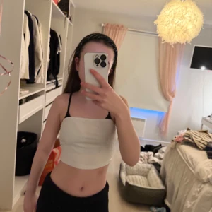 Vit tubtopp - Säljer en enkel och stilren vit tubtopp. Perfekt för sommardagar eller som basplagg under andra toppar. Gjord i mjukt material för en bekväm passform.