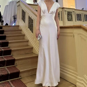 Champagnefärgad långklänning  - Champagnefärgad långklänning i satin med v-ringning och korta ärmar. Klänningen har en vacker öppen rygg som ger en extra detalj. Super fin som balklänning och bara använd en gång💖💖skriv för fler bilder, frakt och tull avgift tillkom när jag köpte den för 1900kr