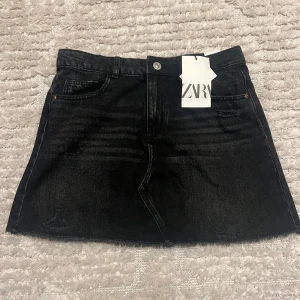 Svart jeanskjol från Zara - Snygg svart jeanskjol från Zara med slitna detaljer. Aldrig använt och är för liten nu💘 Riktigt snygg kjol!!😍