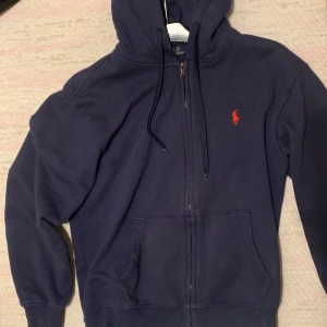 Ralph Lauren Hoodie - Marinblå Ralph Lauren Hoodie. Storlek M, kan ev ha krympts lite i tvätt så S/M. Den är i använt men bra skick! Använts cirka 15 gånger