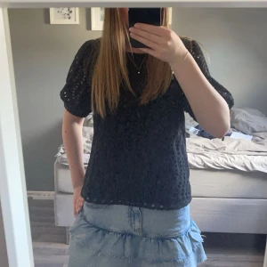 Svart blus med mönster - Säljer en jättefin svart blus med mönster. Rund halsringning med en knapp i ryggen.