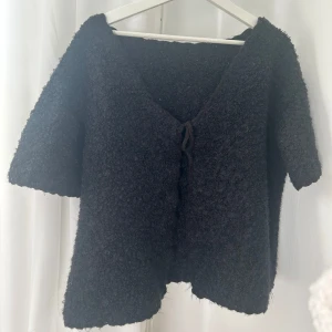Svart kofta  - Mysig svart kofta med knyt framtill. Den har en fluffig textur. En stilren och bekväm tröja som passar till många tillfällen.💕köpt av en annan tjej på plick