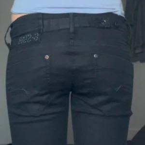 Lågmidjade jeans från G-Star - Snygga svarta jeansbyxor från G-Star med en tight passform. Byxorna har klassiska fem fickor och en knappgylf. Perfekta för en stilren look.