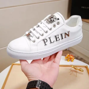 Sneakers Philipp Plein - Flera storlekar! Stilrena vita sneakers med silverdetaljer från Philipp Plein. Skorna har en dekorativ metallapplikation och texten 'PLEIN' på sidan. Tillverkade i skinn med snörning framtill och en bekväm sula. 