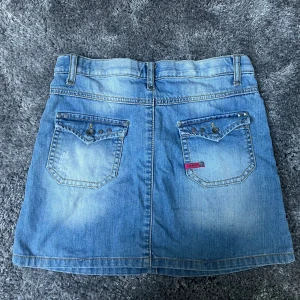 Ljus Denim Kjol - En super söt ljus denim kjol med silviriga knappar och detaljer både fram och bak! Perfekt till våren och sommaren🤍                                                 Obs!! Liten i storlek, storlek 146 i barn!!!!🙌🏼