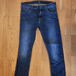 Blå jeans från Lee - Snygga blå jeans från Lee i modellen Luke. De har en klassisk femficksdesign och en bekväm passform. Perfekta för en avslappnad stil. Tillverkade i ett slitstarkt material som håller länge.