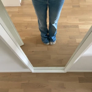 Blå jeans med bootcut - Säljer ett par klassiska blå jeans med bootcut. De har en normal passform och är perfekta för en avslappnad stil. Jeansen har en traditionell femficksdesign och är tillverkade i ett slitstarkt denimtyg.