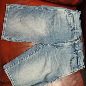 Blå jeansshorts från Levi's Line 8 - Snygga blå jeansshorts från Levi's Line 8. De har en klassisk design med fem fickor och en bekväm passform. Perfekta för en avslappnad stil.
