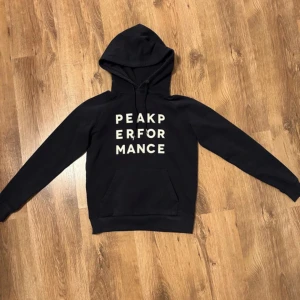 Marinblå hoodie från Peak Performance - Peak performance hoodie använd men i fint skick! Mörkblå med tryck på framsidan, storlek S. Skriv för fler bilder eller mått!