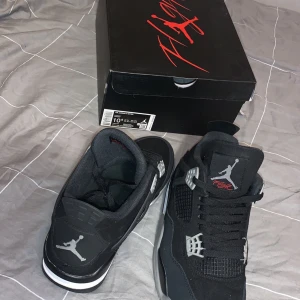 Jordan 4 black canvas  - Snygga svarta Nike Air Jordans med grå och vita detaljer. Skorna har en klassisk design med snörning och den ikoniska Jumpman-loggan på tungan och hälen. Perfekta för dig som vill ha en stilren och sportig look.