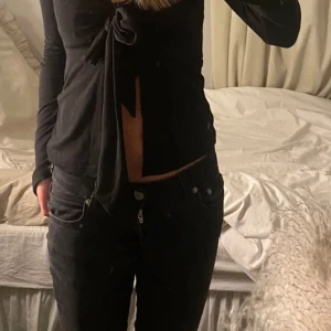 Svart långärmad topp med knyt - Snygg svart långärmad topp med knyt framtill. Bra skick och har inga defekter💗