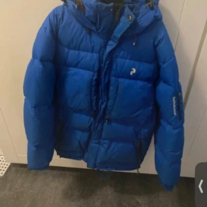 Vinterjacka Peak performance  - Jackan är i storleken M och är i bra skick, det finns två mörka märken vid armen och luvan men det går bort med tvätt.