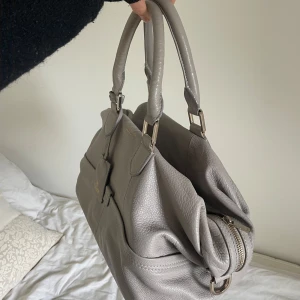 Tiger of Sweden väska - Superfin ljusgrå / beige väska från Tiger of Sweden i fint använt skick (gulddetaljer) yttertyg 100% läder och innertyg 100% bomull