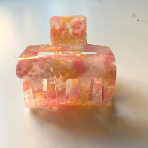 Rosa hårklämma - Rosa hårklämma med rosa och vita/ljusgula inslag. Passar många stilar!! Använd en gång. 