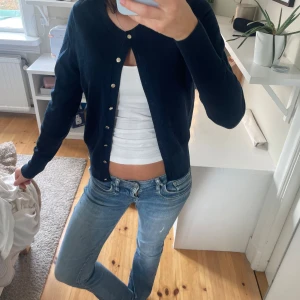 Mörkblå kofta! - Säljer denna mysiga koftan då den inte används! Från Lindex och använd ett fåtal gånger. Guldiga knappar och lite tunnare material. Nypris ca 400kr.