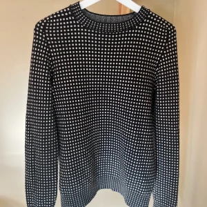 Svart och vit mönstrad tröja från Acne Studios - Säljer en superfin svart och vit mönstrad tröja från Acne Studios. Den är gjord av 70% ull och 30% kashmir, vilket gör den både varm och mjuk. Perfekt för höst och vinter! Storleken är M men sitter mer som S. Passar både tjej å kille. Skick 8,5/10.  