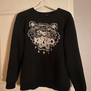 Svart kenzo swertshirt  - Säljer min svarta riktiga kenzo tröja, Tröjan har ett håll nere i ärmen men som är jätte lättsyt!  I storleken M men står XL som barnstorlek, skriv för fler bilder eller frågor🙂