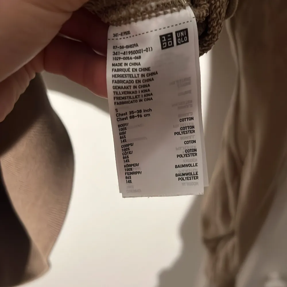 Säljer en snygg beige tröja från Uniqlo i storlek S. Den är gjord av en skön blandning av bomull och polyester, perfekt för både vardag och mysiga stunder. Tröjan har en klassisk design med långa ärmar och ribbade kanter vid hals, ärmslut och nederkant.. Tröjor & Koftor.