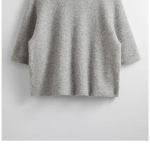 Grå tröja från & Other Stories - Säljer en stilren grå tröja från & Other Stories. Tröjan har en enkel design med trekvartsärmar och är tillverkad i ett mjukt material som ger en bekväm passform. Perfekt för en avslappnad look.