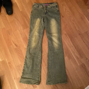Bootcut jeans från edikted - Snygga bootcut jeans i en klassisk blå färg med en slags gul wash. Aldrig använda. Köpta för ca 1300kr.