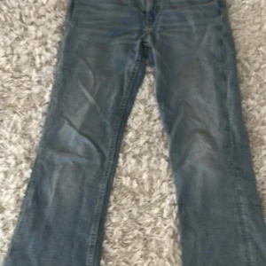 Blå jeans från Gina Tricot - Snygga blå jeans från Gina Tricot med en klassisk bootcut-stil. Perfekta för en avslappnad look. De har en traditionell femficksdesign och en bekväm passform i storlek 158. Används ej, därav det låga priset.