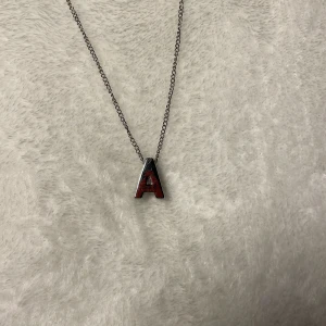 Sliver färgat halsband med A - Snyggt halsband med ett hänge i form av bokstaven 'A'. Nytt halsband, aldrigt använt.  